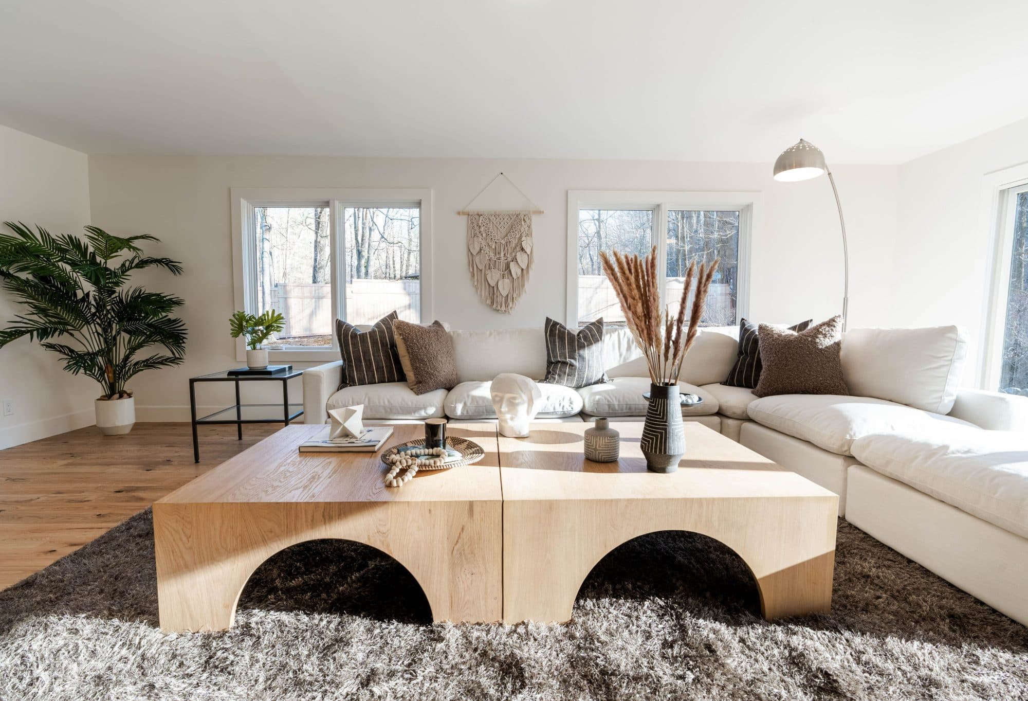 Hawley family room — white sectional, oak coffee table, and woven wall hanging