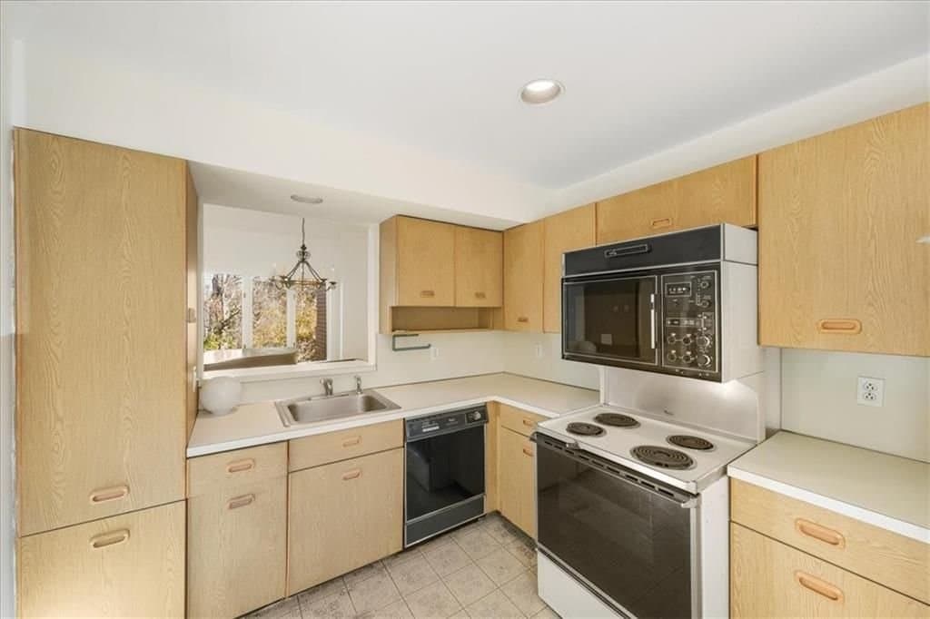 Eagle Bay before — the original oak kitchen with laminate counters and dated appliances